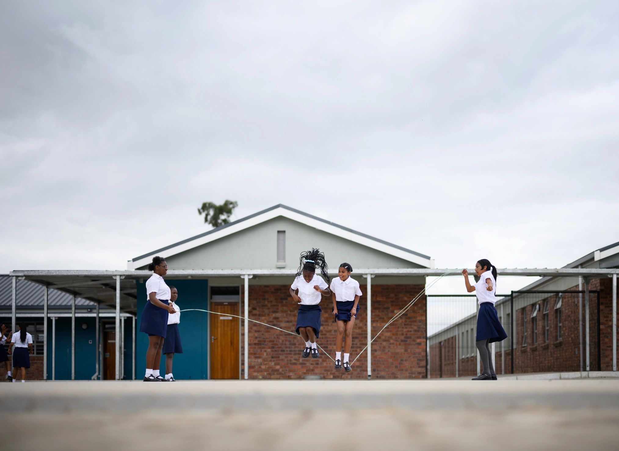 Students skipping rope in a school yard