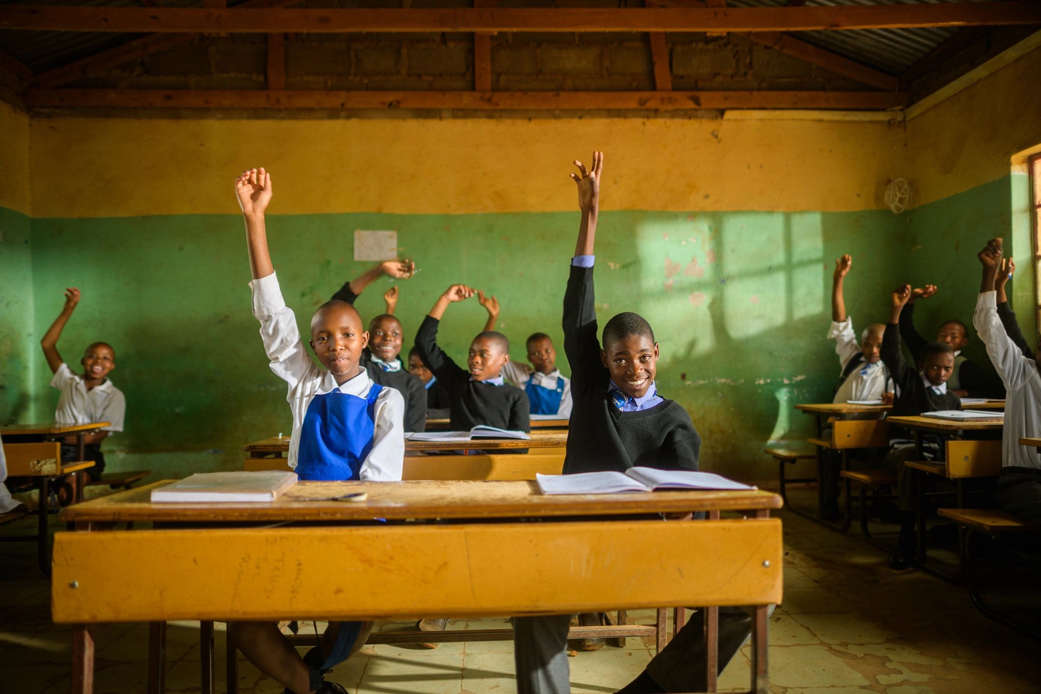 Students in a classroom raising their hands