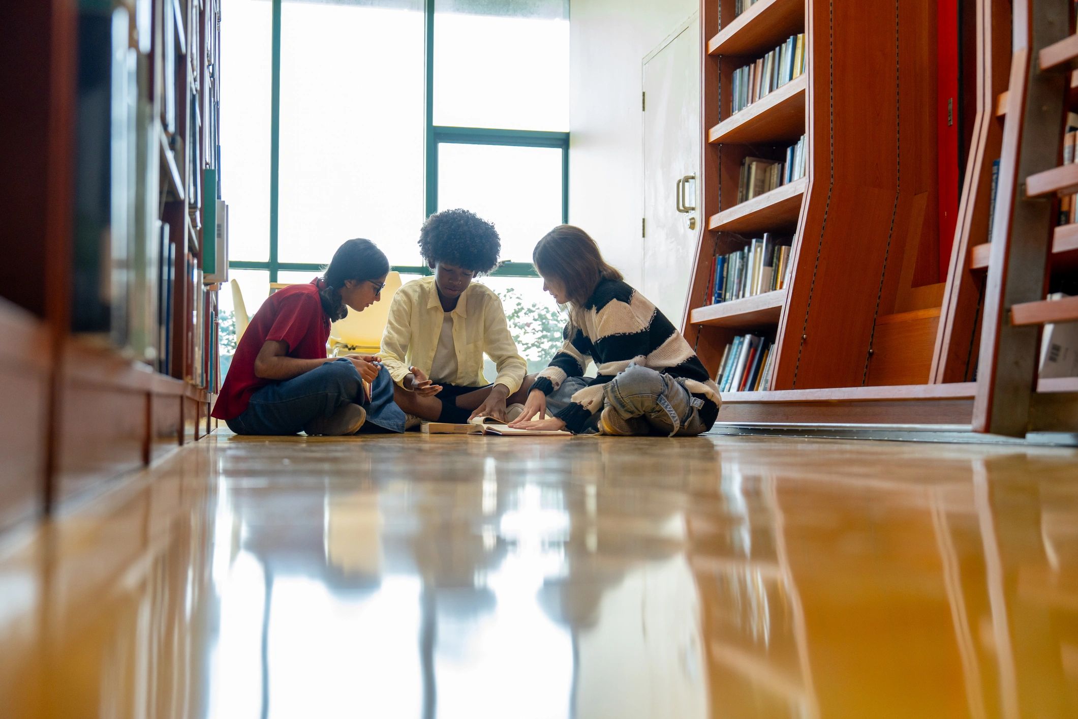 Students reading and discussing in a library
